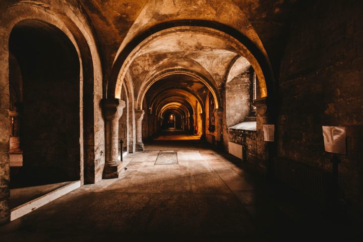 a stone building that has a bench in a dark room